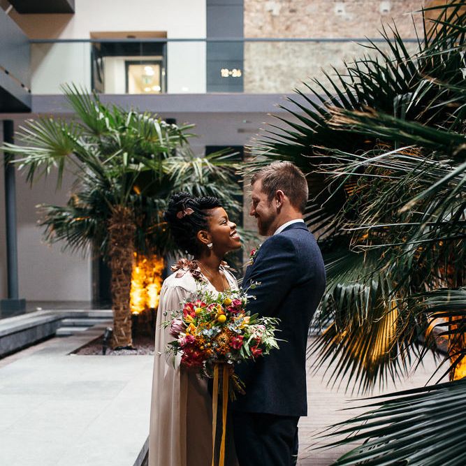 Bride in Bespoke Ailsa Monroe Jumpsuit & Cape | Groom in Next Navy Wool Suit | Relaxed Industrial Wedding at Ocean Studios, Plymouth | Freckle Photography