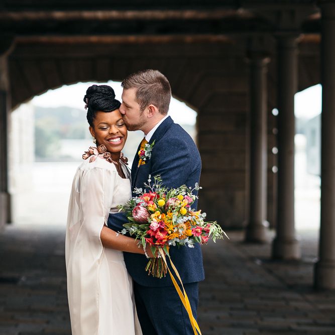 Bride in Bespoke Ailsa Monroe Jumpsuit & Cape | Groom in Next Navy Wool Suit | Relaxed Industrial Wedding at Ocean Studios, Plymouth | Freckle Photography