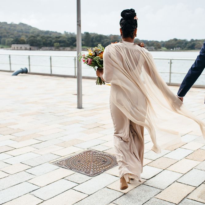 Bride in Bespoke Ailsa Monroe Jumpsuit & Cape | Groom in Next Navy Wool Suit | Relaxed Industrial Wedding at Ocean Studios, Plymouth | Freckle Photography