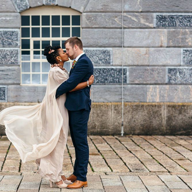 Bride in Bespoke Ailsa Monroe Jumpsuit & Cape | Groom in Next Navy Wool Suit | Relaxed Industrial Wedding at Ocean Studios, Plymouth | Freckle Photography