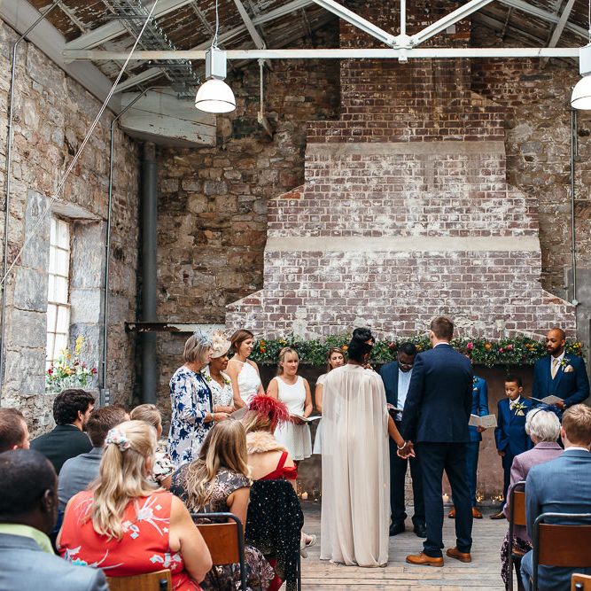 Wedding Ceremony | Bride in Bespoke Ailsa Monroe Jumpsuit & Cape | Groom in Next Navy Wool Suit | Relaxed Industrial Wedding at Ocean Studios, Plymouth | Freckle Photography