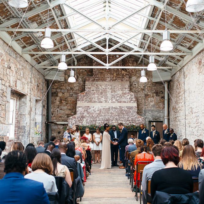 Wedding Ceremony | Bride in Bespoke Ailsa Monroe Jumpsuit & Cape | Groom in Next Navy Wool Suit | Relaxed Industrial Wedding at Ocean Studios, Plymouth | Freckle Photography