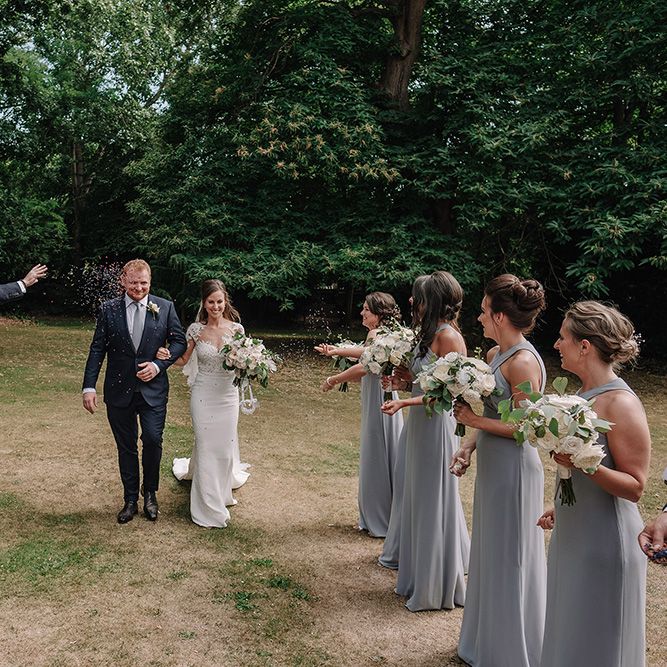 Confetti Exit | Bride in Lace Pronovias Bridal Gown | Groom in Thom Sweeney Suit | White and Silver English Country Garden At Home Marquee Wedding | Jason Mark Harris Photography
