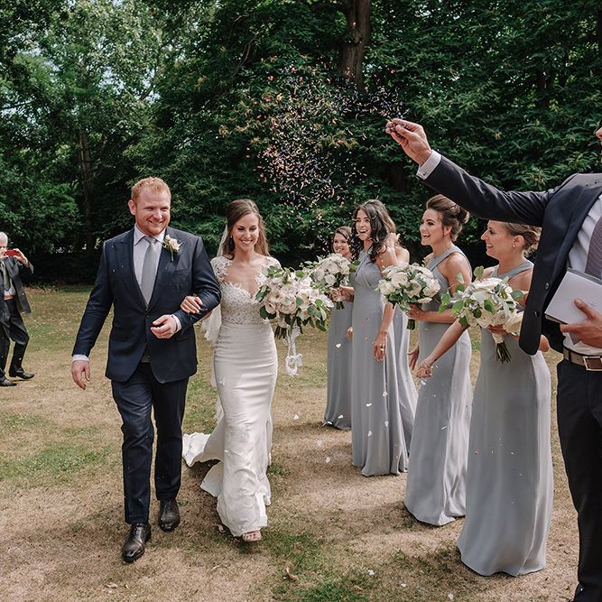 Confetti Exit | Bride in Lace Pronovias Bridal Gown | Groom in Thom Sweeney Suit | White and Silver English Country Garden At Home Marquee Wedding | Jason Mark Harris Photography