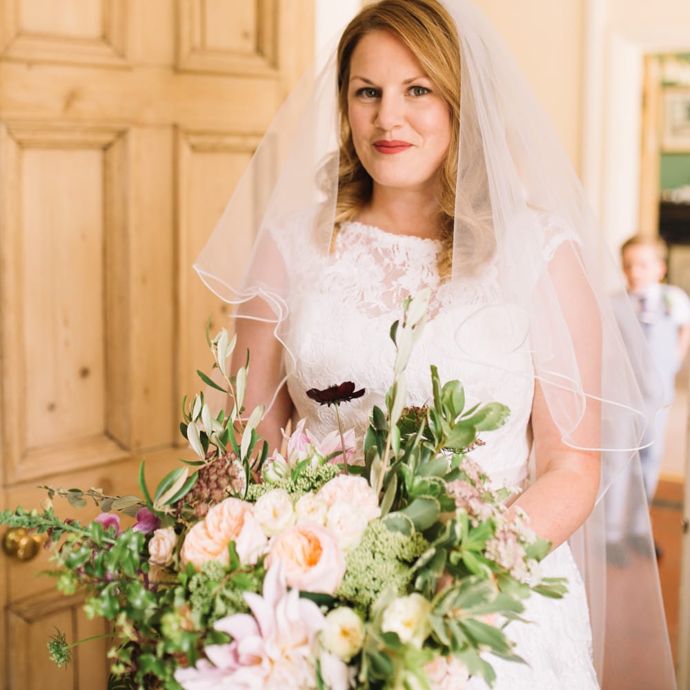Bride in Lace Justin Alexander Wedding Dress & Peach Bouquet