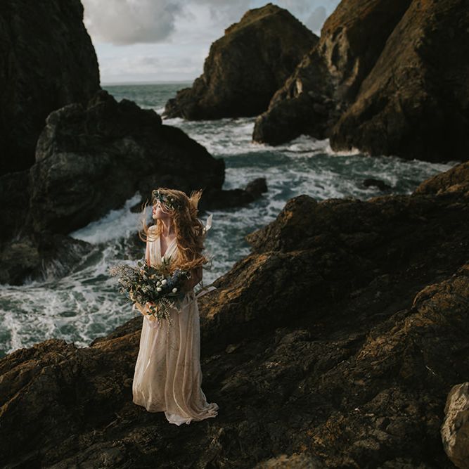 Bride standing amongst rocks at sunset - moody wedding photography