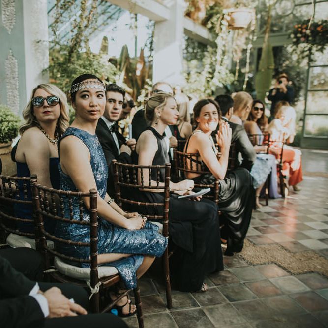 Seated wedding guests at ceremony turn to see couples entrance