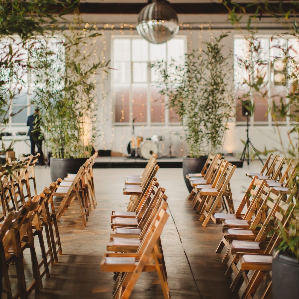 Warehouse Wedding With Wooden Chairs & Foliage Installation | Images by Frances Sales
