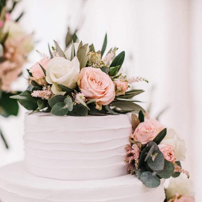 White Wedding Cake Covered In Flowers