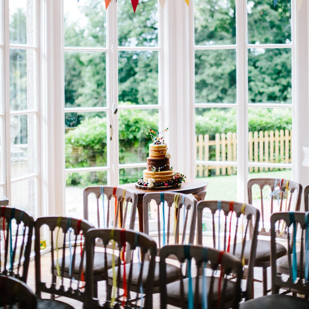 Homemade Naked Wedding Cake Table with Bunting & Ribbon Decor | Colourful DIY Wedding at Barley Wood Country House in Somerset | A Thing Like That Photography