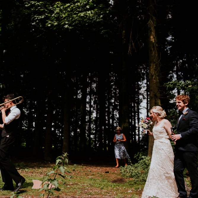 Brass Band Procession | Bride in Catherine Deane Gown | Groom in Ben Sherman Suit, Bow Tie & Gingham Shirt | Colourful Outdoor Wedding at Lineham Farm in Leeds | Shutter Go Click Photography