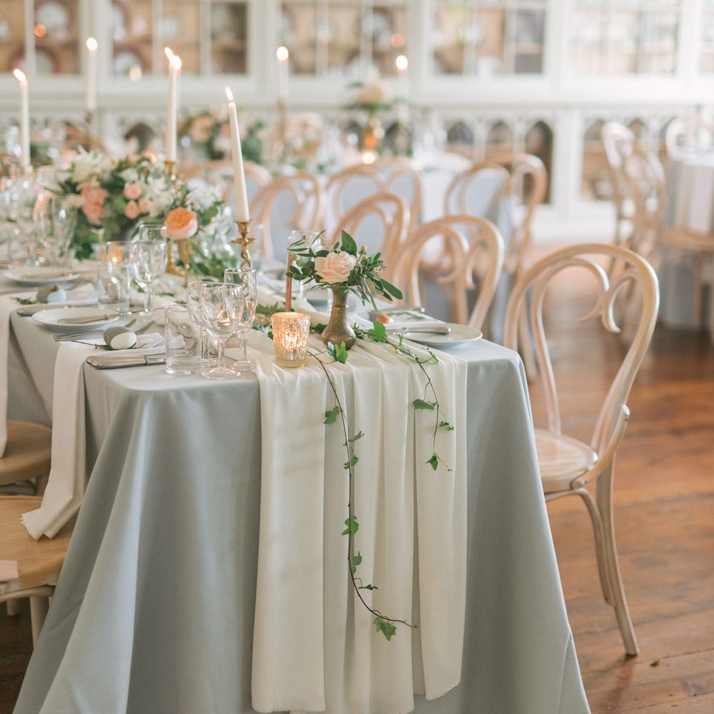 Wedding breakfast tablescape with bent wood chairs, table cloth and tapered candles - Fine Art Wedding Photographer