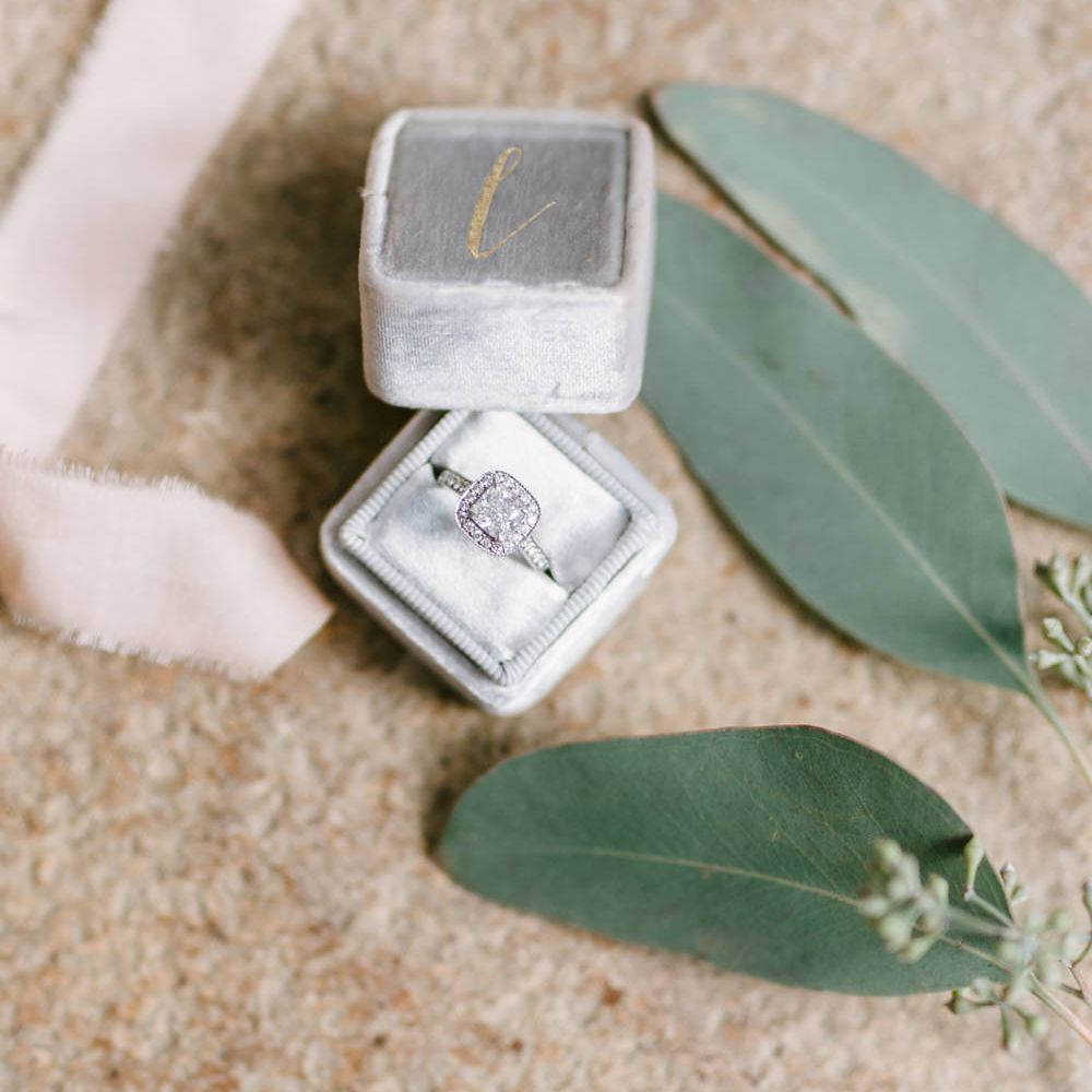 Close up off wedding ring in grey velvet box with eucalyptus leaves Fine Art Wedding Photographers