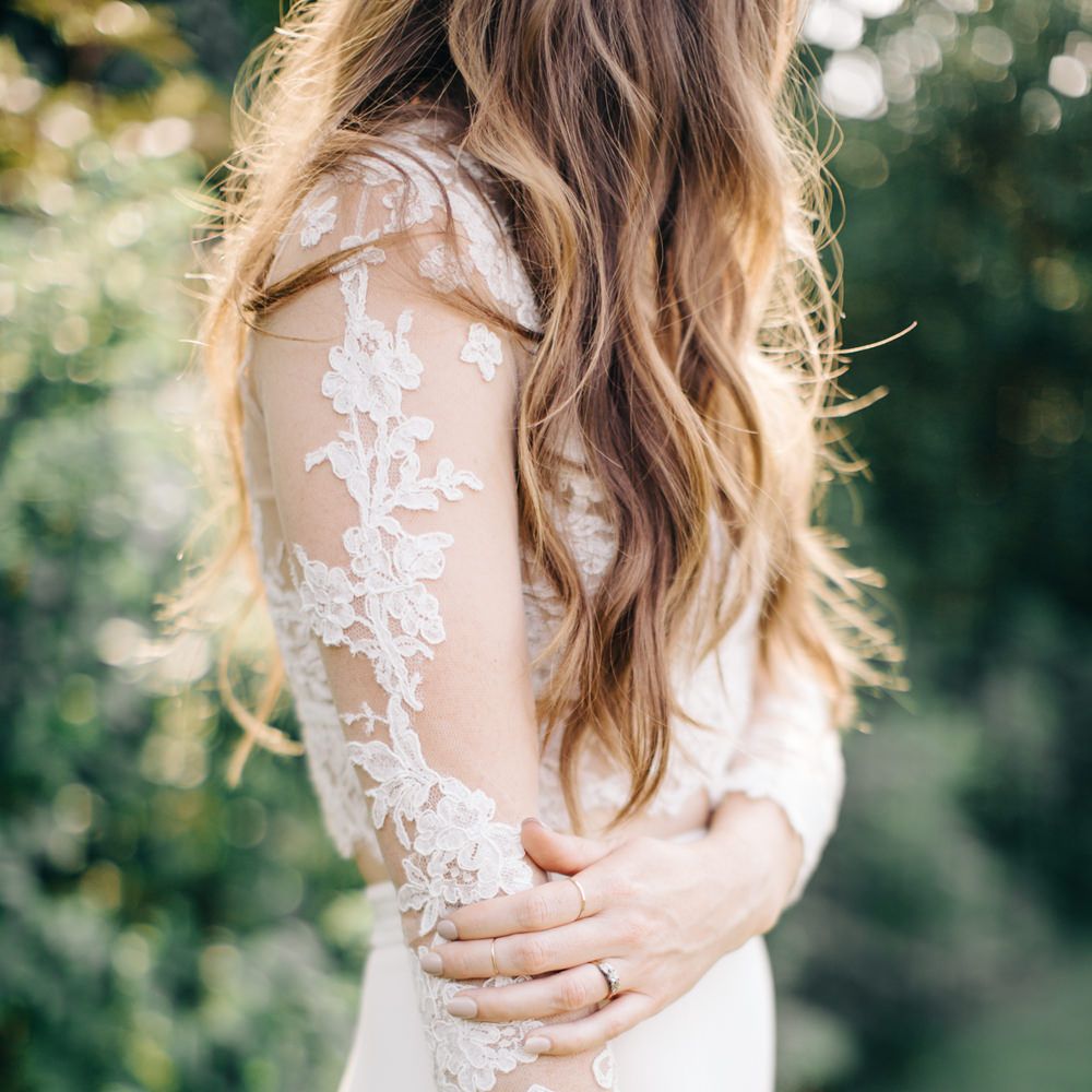 Close up of bride touching lace wedding dress sleeve - Fine Art Wedding Photographer