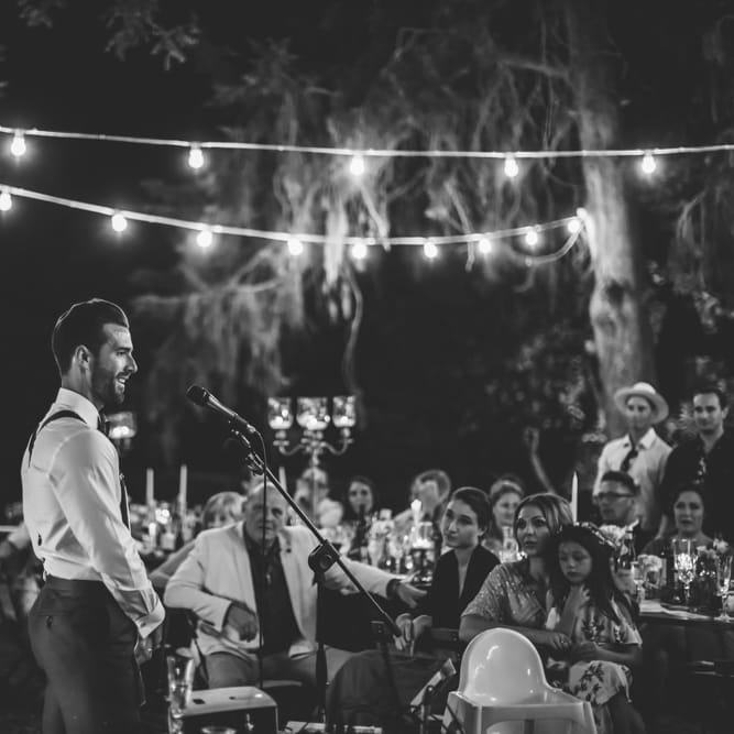 Wedding Speeches Under Festoon Lights | Bride in Morgan Davies Gown | Groom in Suit Supply | D&A Photography | Ben Walton Films