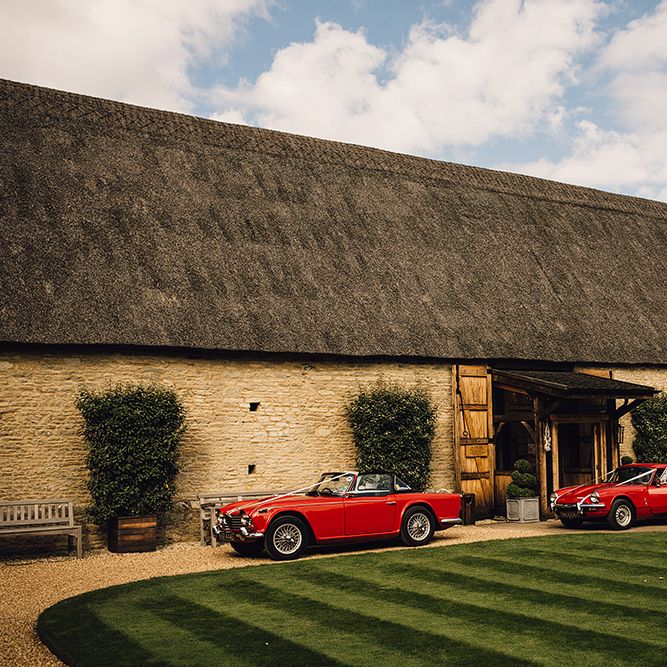 Red Vintage Cars Outside The Tythe Barn in Oxfordshire