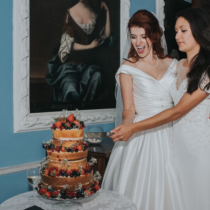 Two Brides inOcean Bridal Studio Wedding Dress & White Leaf Bridal Wedding Dress Cutting The Cake