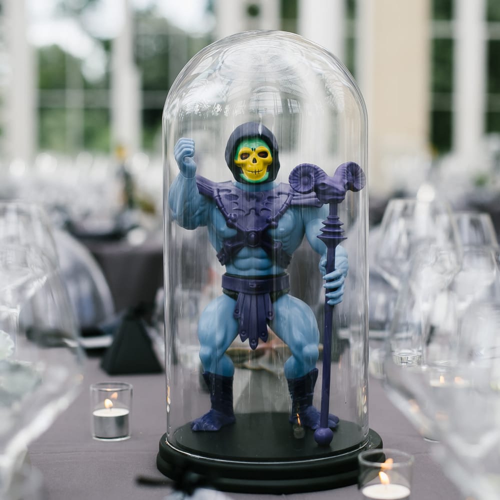 Iconic 80s Figure (Skeleton   He Man) in Bell Jar Table Centrepiece Wedding Decor | Monochrome Wedding at Syon Park London | Chris Barber Photography | Second Shooter Beatrici Photography
