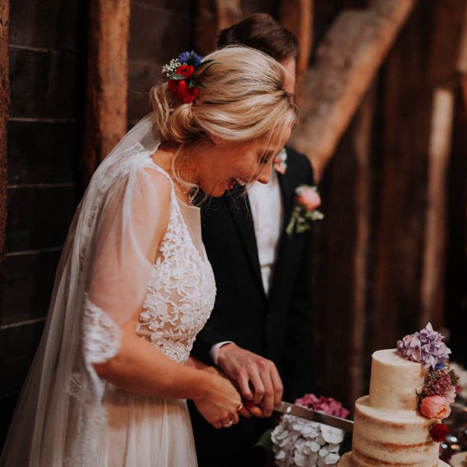Bride & Groom Cutting the Cake | Colourful DIY Barn Wedding at The Manor Barn, Cambridge | Meghan Lorna Photography