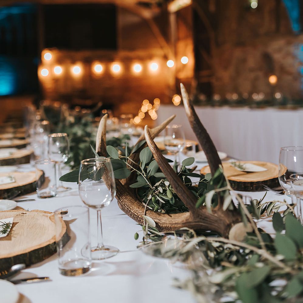 Rustic Barn Reception with Wood Slices, Antlers, Fairy Lights & Greenery