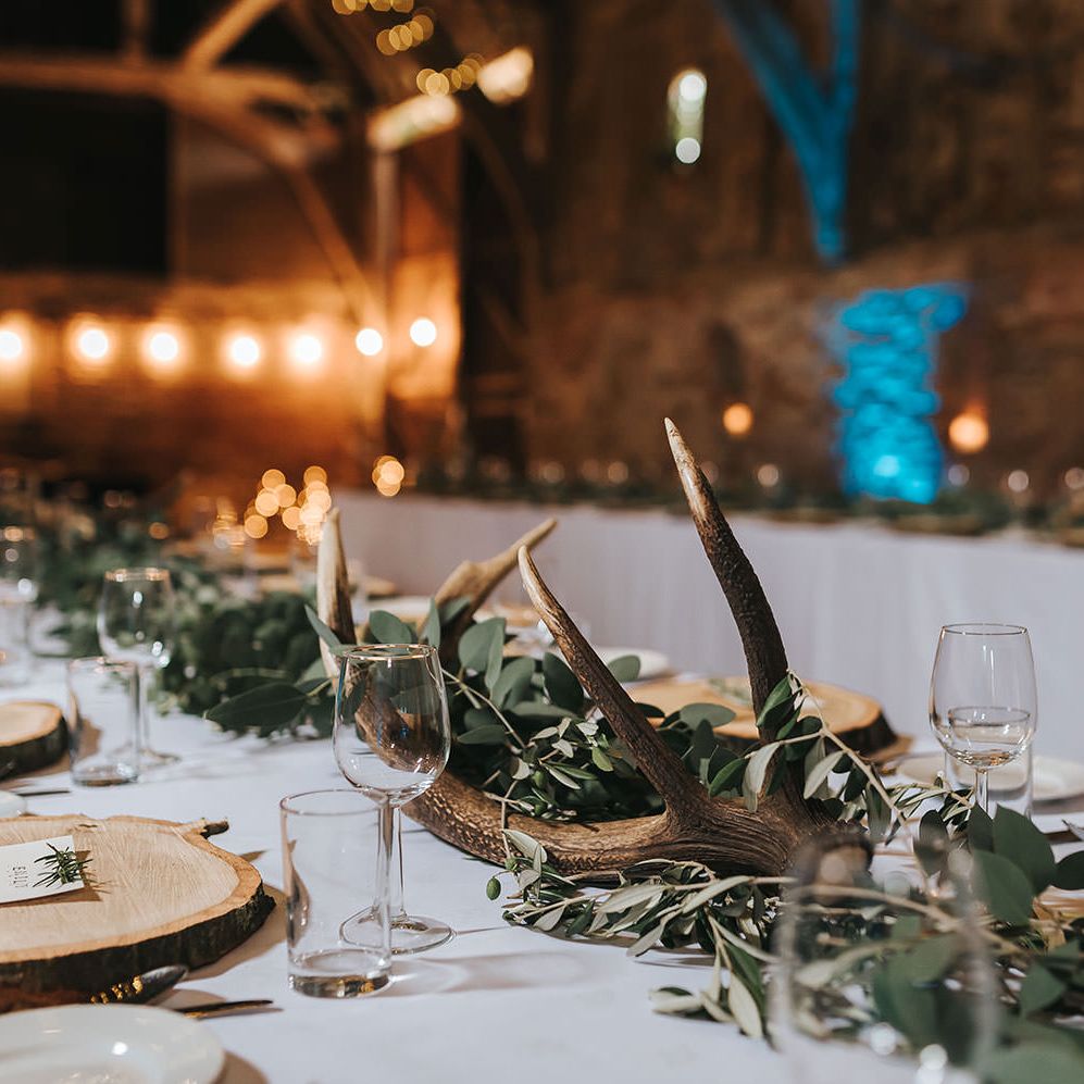 Rustic Barn Reception with Wood Slices, Antlers, Fairy Lights & Greenery