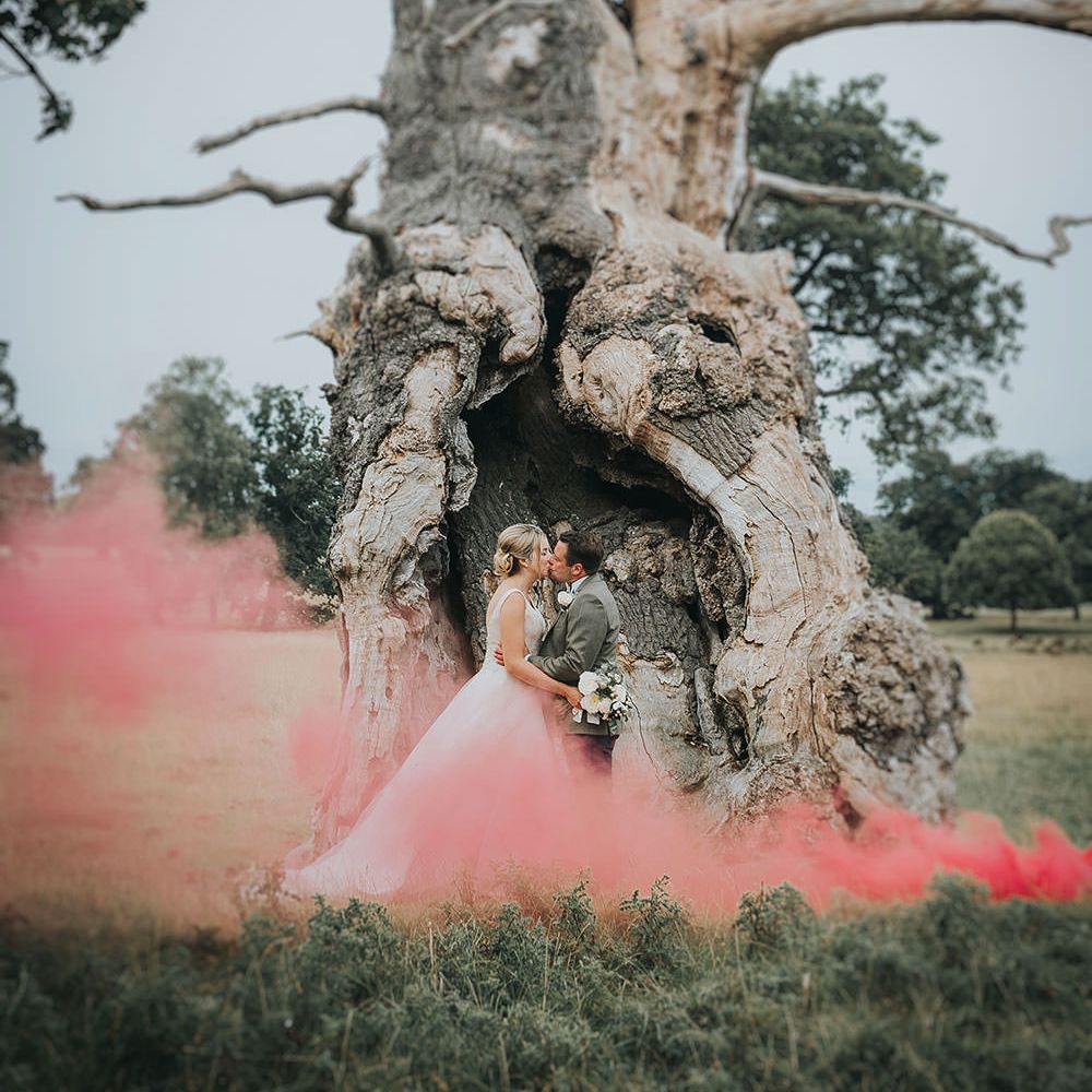 Bride in Phil Collins Bridal Gown & Groom in Chino's & Tweed Jacket at Helmingham Hall Gardens