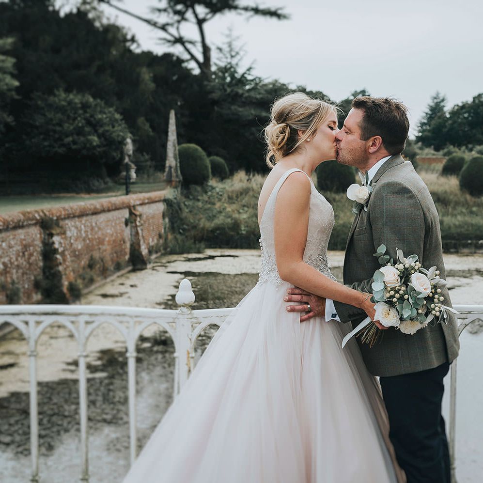 Bride in Phil Collins Bridal Gown & Groom in Chino's & Tweed Jacket at Helmingham Hall Gardens