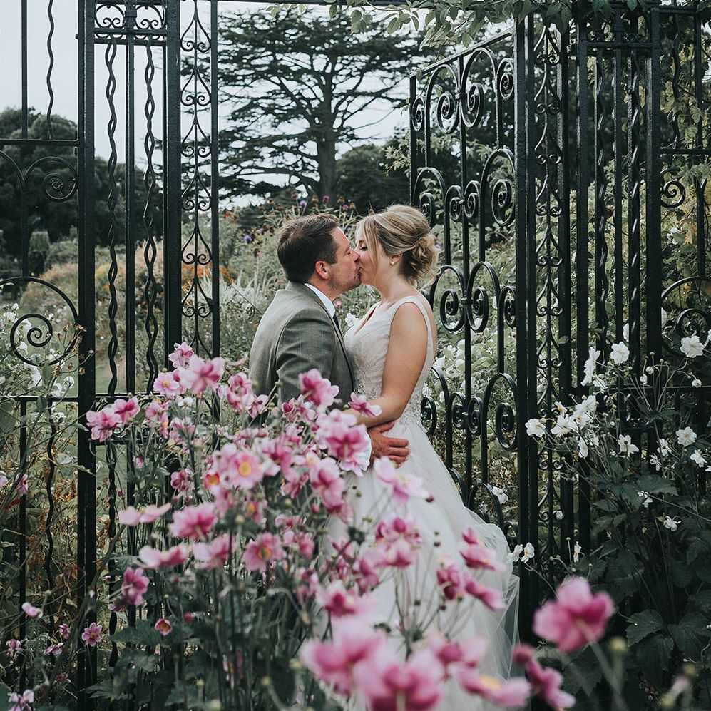 Bride in Phil Collins Bridal Gown & Groom in Chino's & Tweed Jacket at Helmingham Hall Gardens