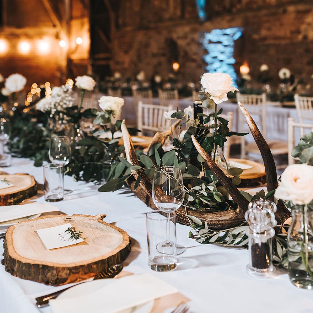 Rustic Barn Reception with Wood Slices, Antlers, Fairy Lights & Greenery
