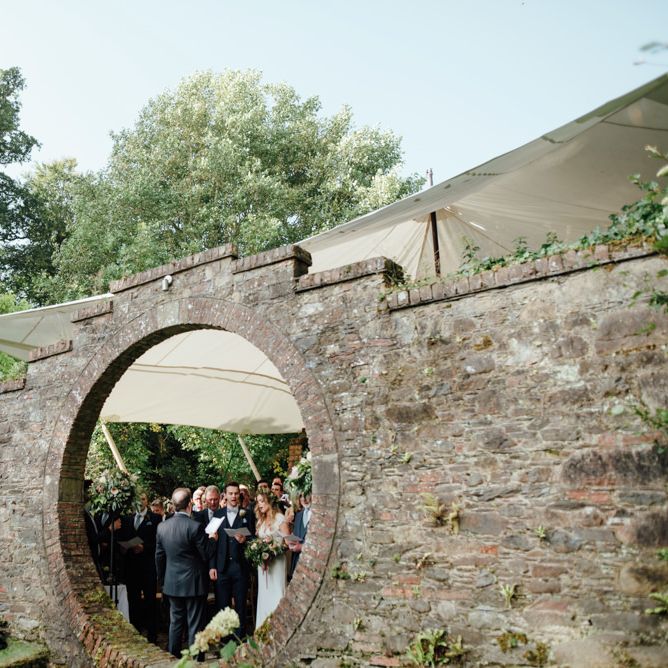 Outdoor Ceremony at Drenagh Estate in Northern Ireland | Bride in Bespoke Suzanne Neville Scarlett Bridal Gown | Protea Bouquet & Flower Crown | The Lou's Photography