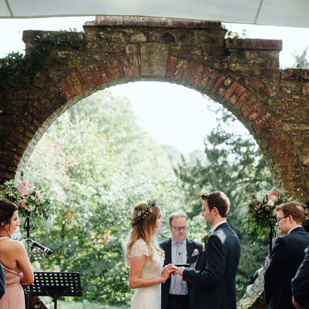 Outdoor Ceremony at Drenagh Estate in Northern Ireland | Bride in Bespoke Suzanne Neville Scarlett Bridal Gown | Protea Bouquet & Flower Crown | The Lou's Photography