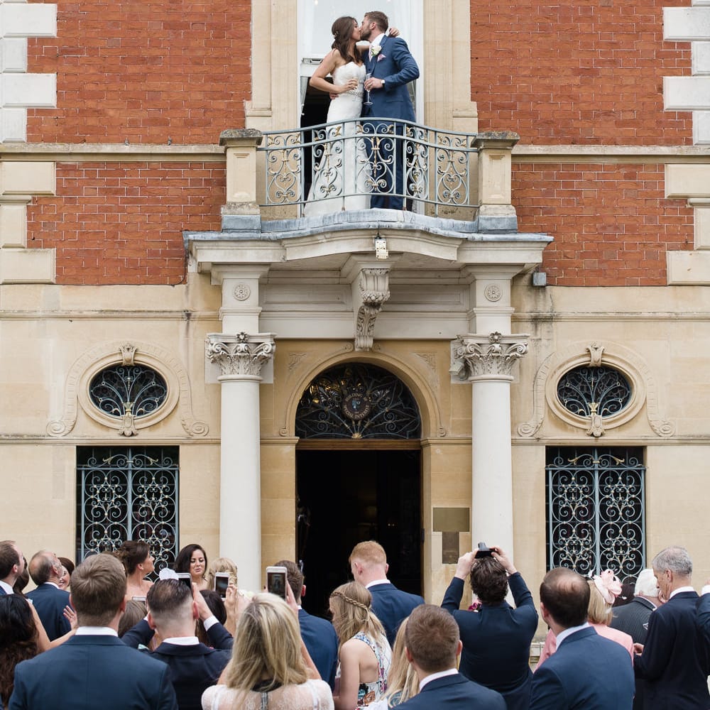 Bride & Groom Balcony Kiss at Fetcham Park in Surrey