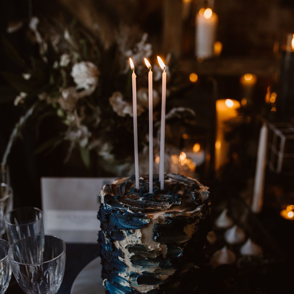 Inky Blue Buns of Fun Bakery Cake with Taper Candles | Nocturn Wedding Inspiration at Godwick Great Barn Planned & Styled by The Little Lending Company | Agnes Black Photography | Film by The Wilde Bride