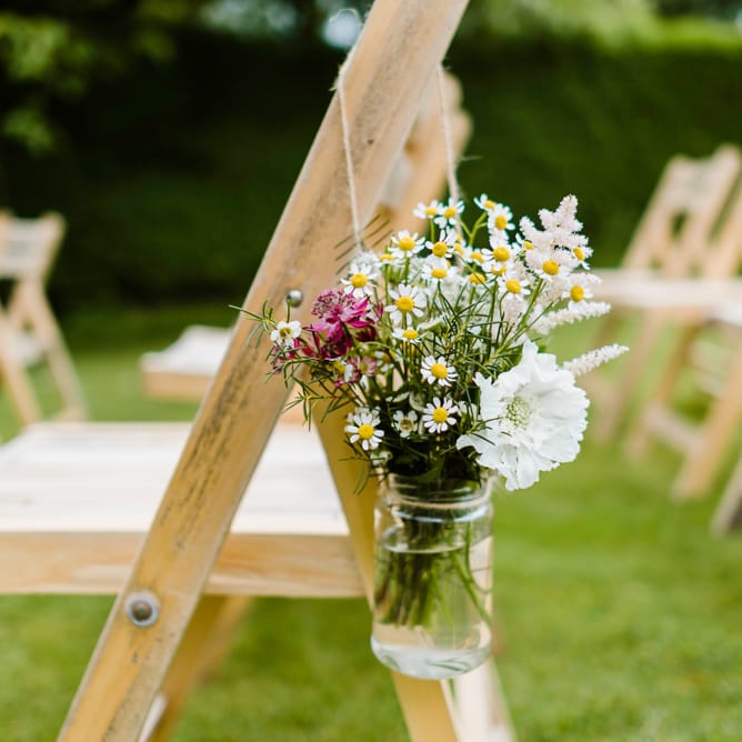 Aisle Chair Back Flowers | Outdoor Ceremony & Rustic Barn Reception at Pennard House Somerset | John Barwood Photography