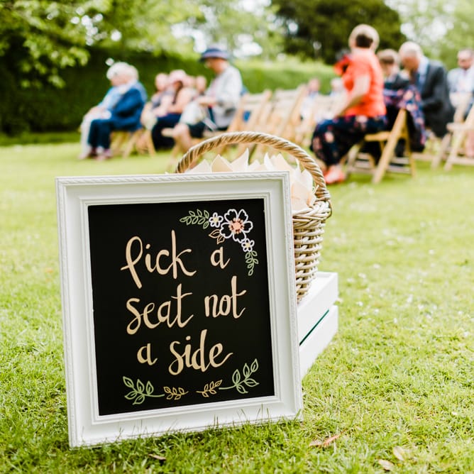 Pick a Seat Not a Side Ceremony Sign | Outdoor Ceremony & Rustic Barn Reception at Pennard House Somerset | John Barwood Photography