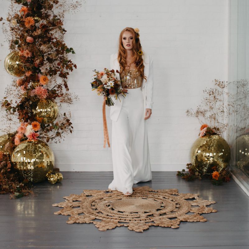 Bride in trouser suit with gold corset at 70s Disco wedding inspiration