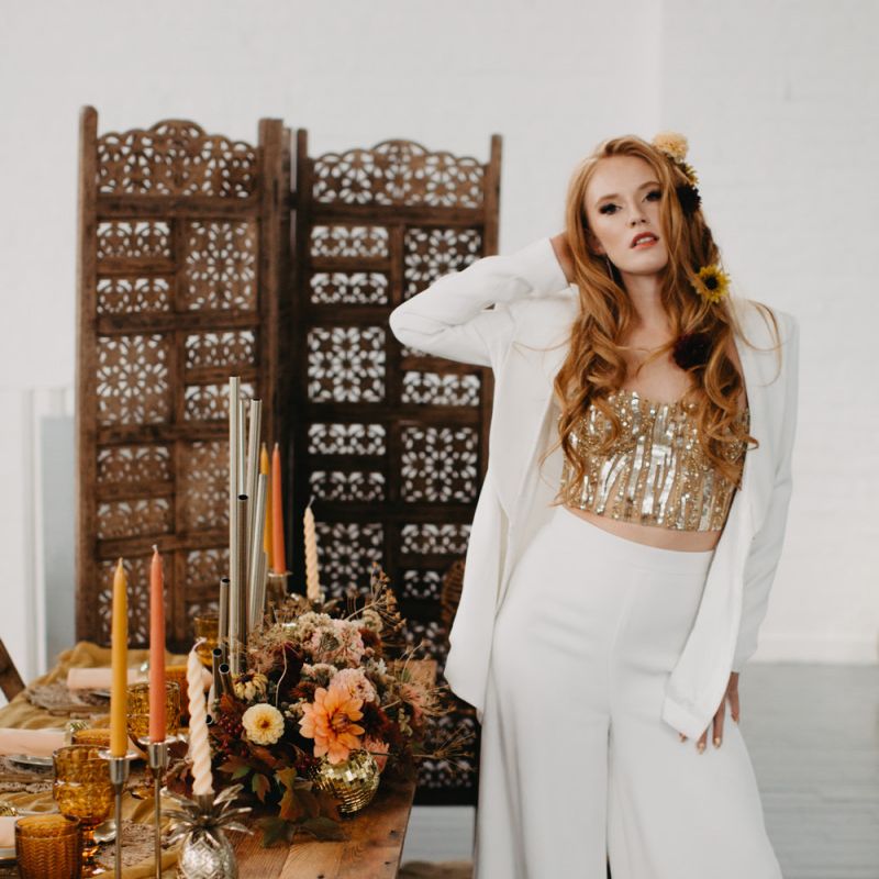 White trouser suit with gold corset for 70s Disco themed wedding