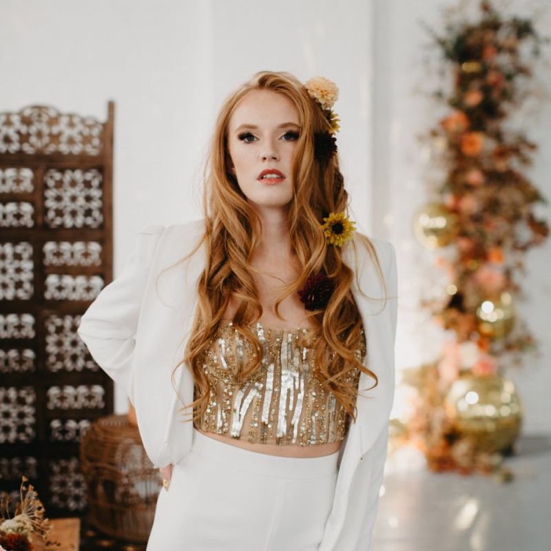 Beautiful bride in gold sequin corset and white trouser suit