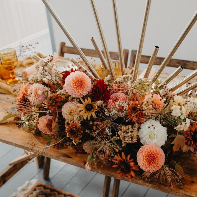 Floral centrepiece wedding decor with dahlias for 70s disco wedding theme