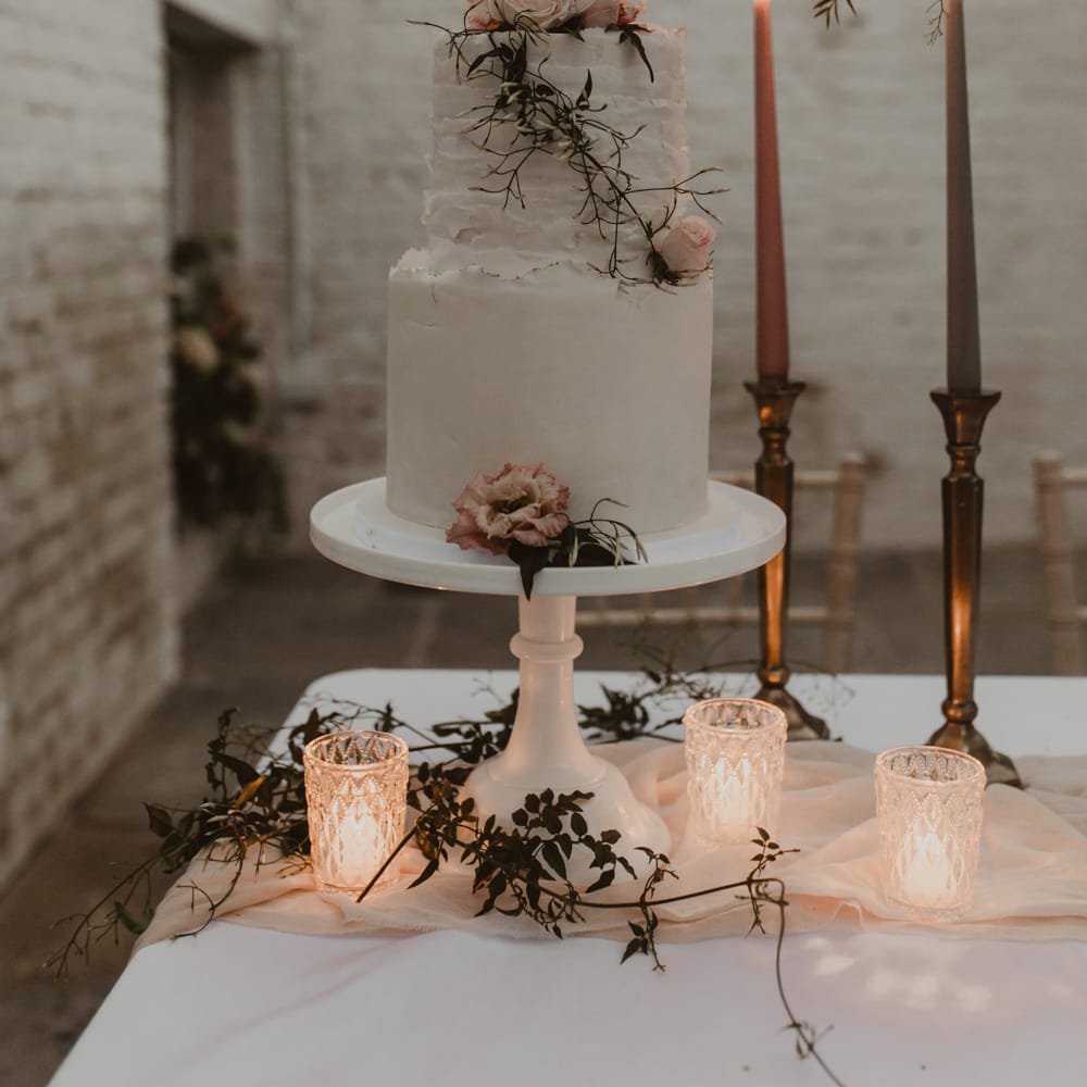 Two Tier Frosted Wedding Cake with Flower Decor &amp; Taper Candles | Romantic Pink and Gold Wedding Inspiration in a Modern Summer House at Garthmyl Hall by KnockKnockPenny Studio | Nesta Lloyd Photography