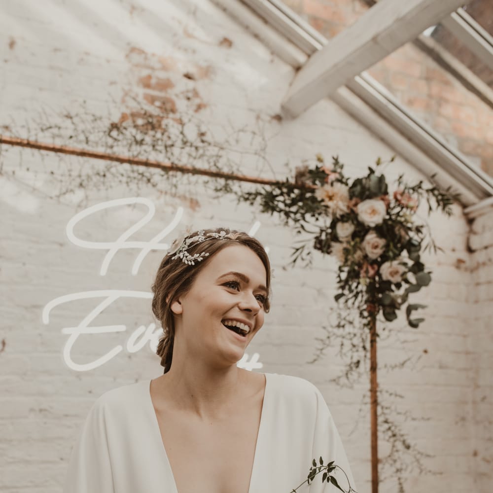 Hanging Neon Happily Ever After Sign on Cooper Frame Wedding Decor | Beautiful Bride in Wrap Wedding Dress &amp; Vine Headpiece | Romantic Pink and Gold Wedding Inspiration in a Modern Summer House at Garthmyl Hall by KnockKnockPenny Studio | Nesta Lloyd Photography