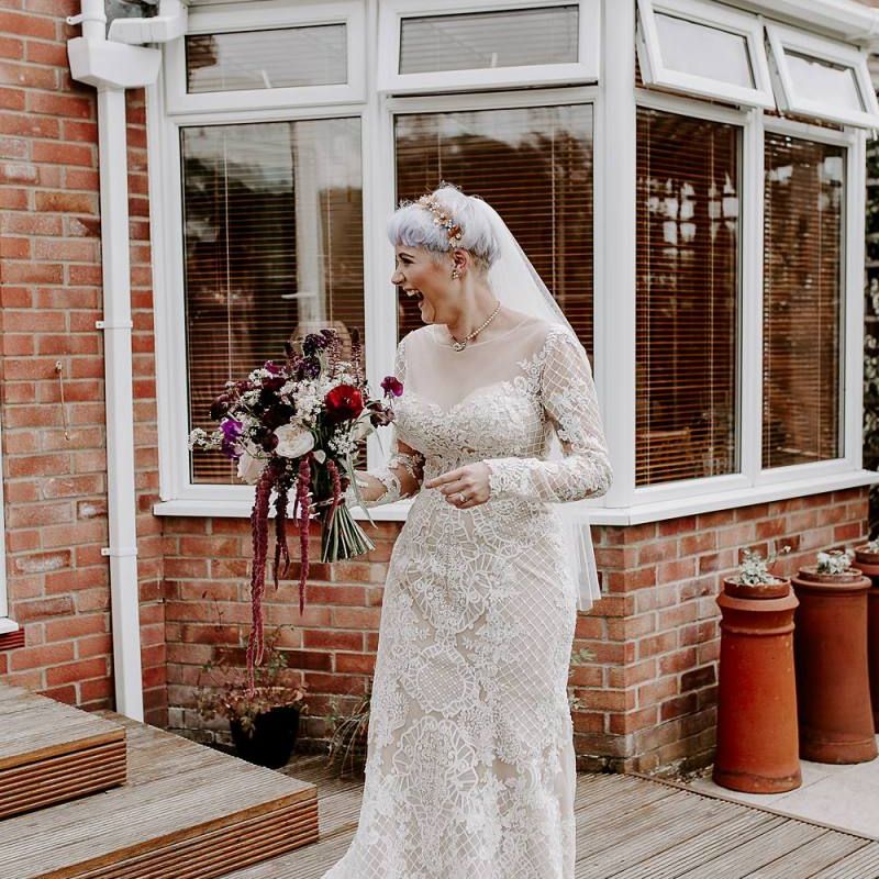 Boho bride in lace Lillian West wedding dress with long sleeves