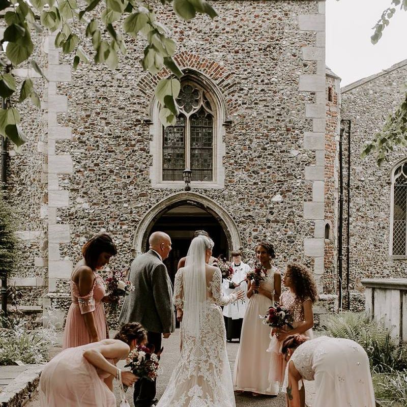 Bride in Lillian West wedding dress outside the church