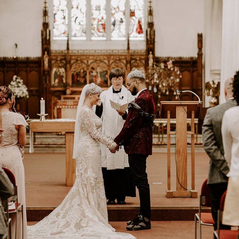 Bride and groom standing at the altar holding hands