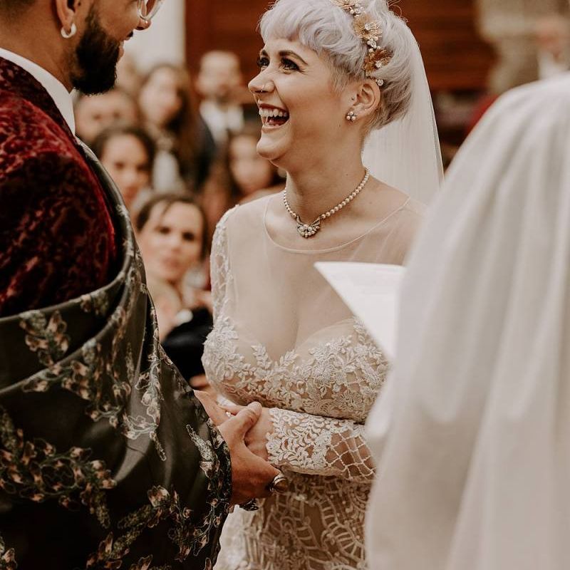 Bride with short hair and bridal crown laughing during the wedding ceremony