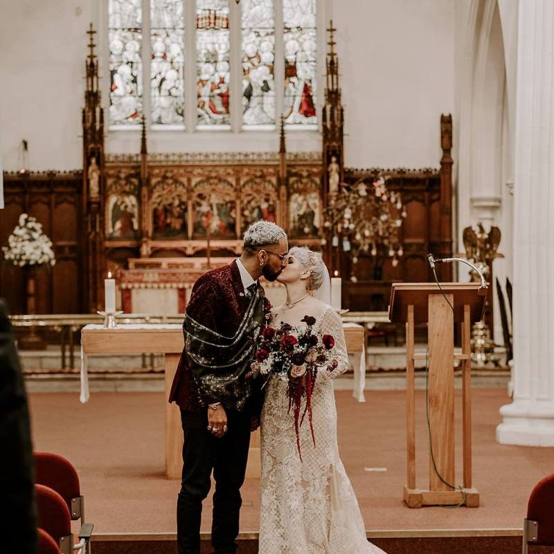Stylish bride and groom kissing during the wedding ceremony