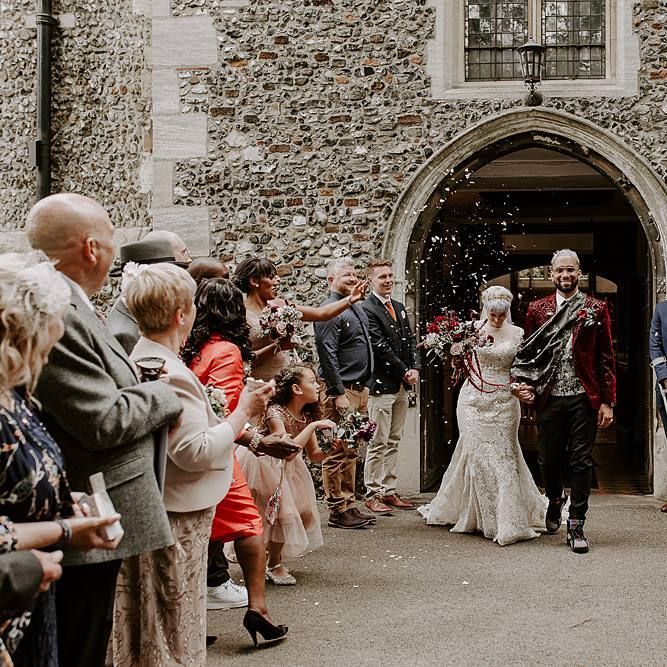 Bride and groom confetti exit with bride in lace Lillian West wedding dress