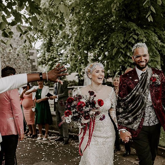 Stylish bride and groom confetti exit with bride in Lillian West wedding dress