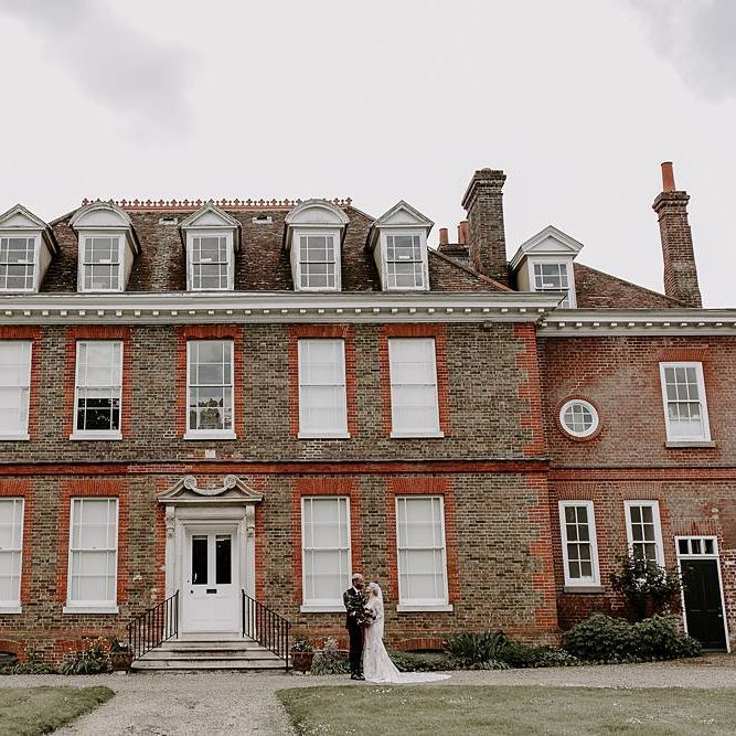 Bride and groom portrait outside their wedding venue Abbots Hall, Suffolk