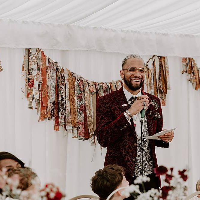 Groom giving a wedding speech with fabric bunting backdrop